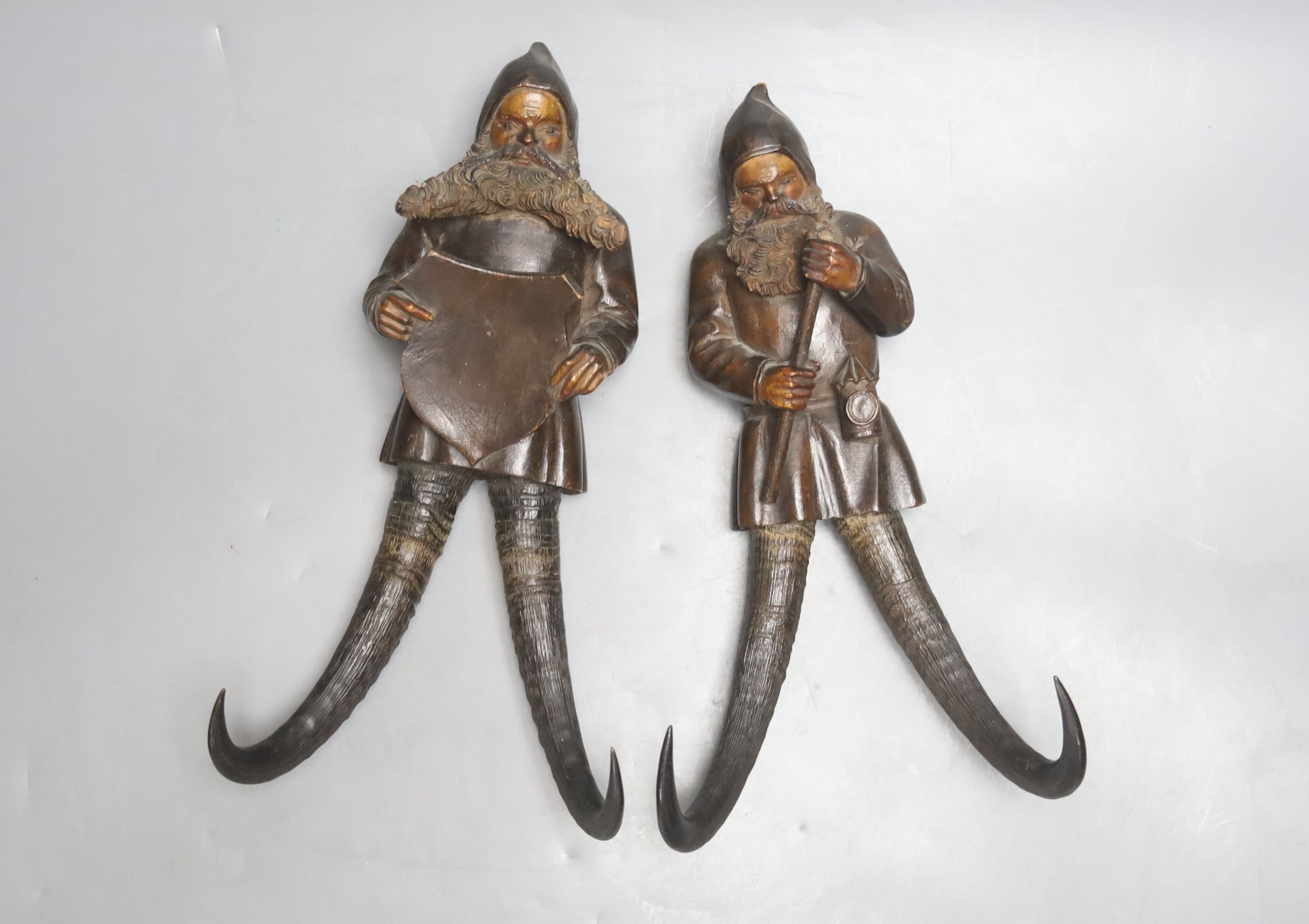 Two Black Forest chamois antler whip hooks, each with carved wood figural 'gnome' surmount